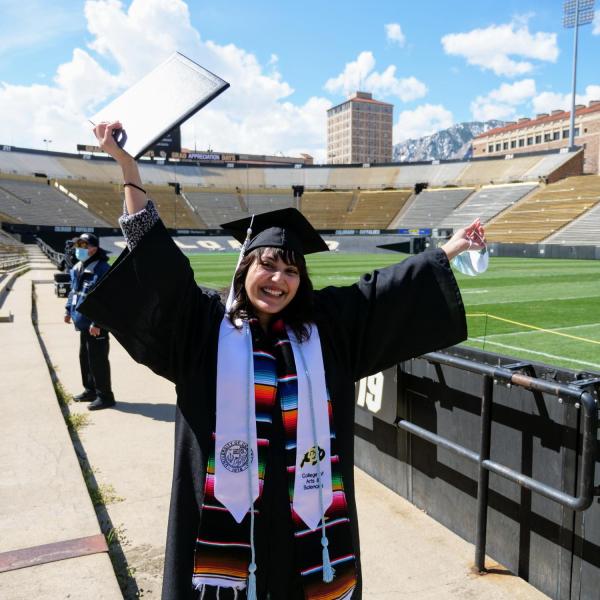 Valeria Ayala Alonso celebrates after getting her photo taken at Folsom Field during Grad Appreciation Days events
