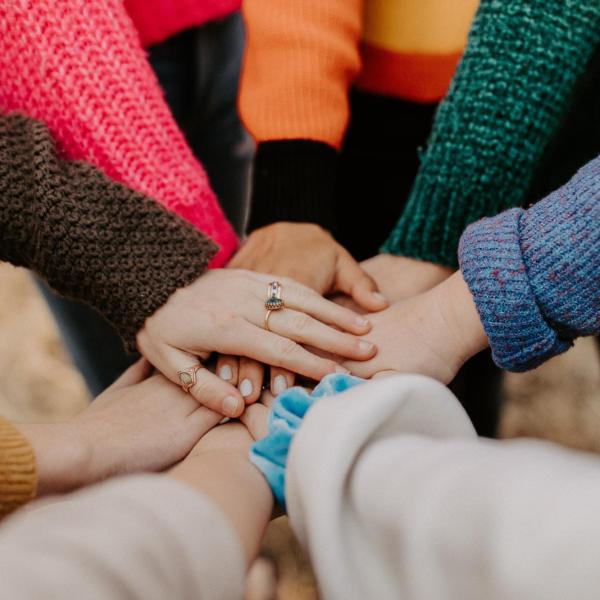 People putting hands together in a circle