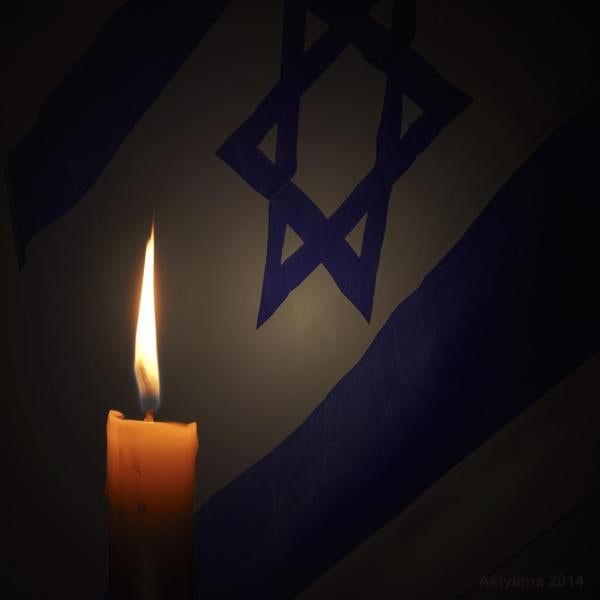 Candle burns with Jewish star in background