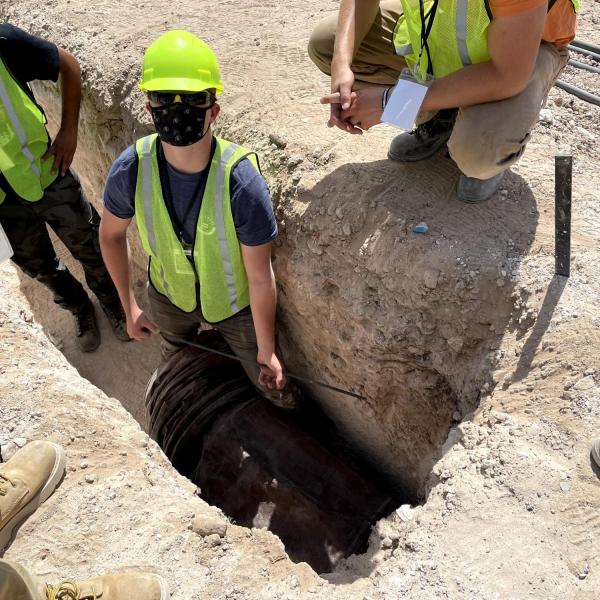 CU Hyperloop team members stand in a hole during the competition