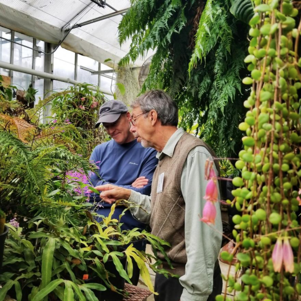 Tom Lemieux speaks with a man inside CU Boulder's EBIO greenhouse.