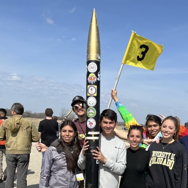 Students standing near a research rocket that they built.