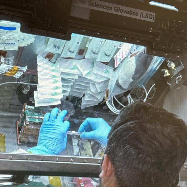 An astronaut working with one of the experiments aboard the International Space Station.