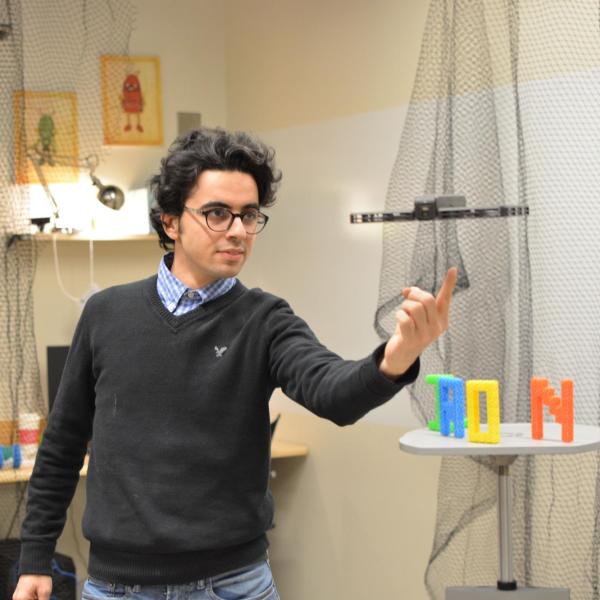 PhD student Hooman Hedayati interacts with hovering robot