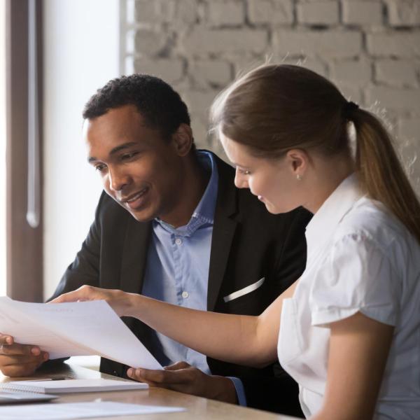 two colleagues look over documents in an office