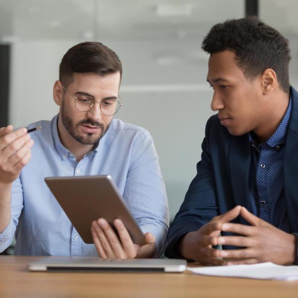 Two professional people looking at a tablet