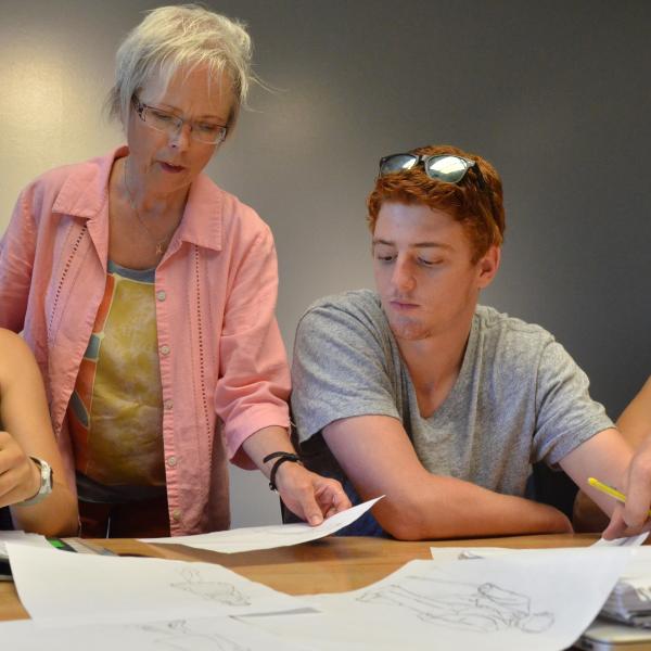 Faculty member Jane Page assists two students in a Shakespeare class
