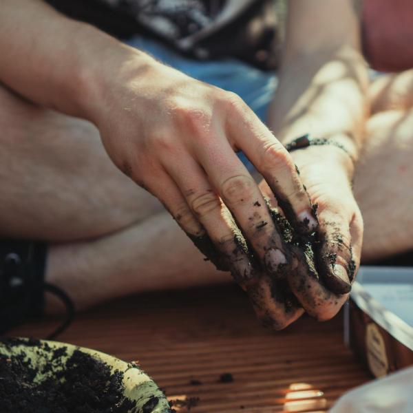 person with soil on hands