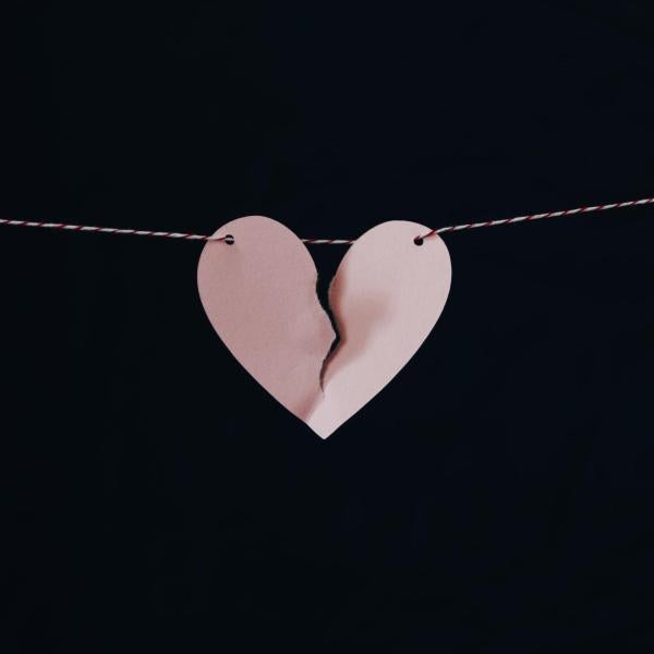 Pink paper heart torn in half