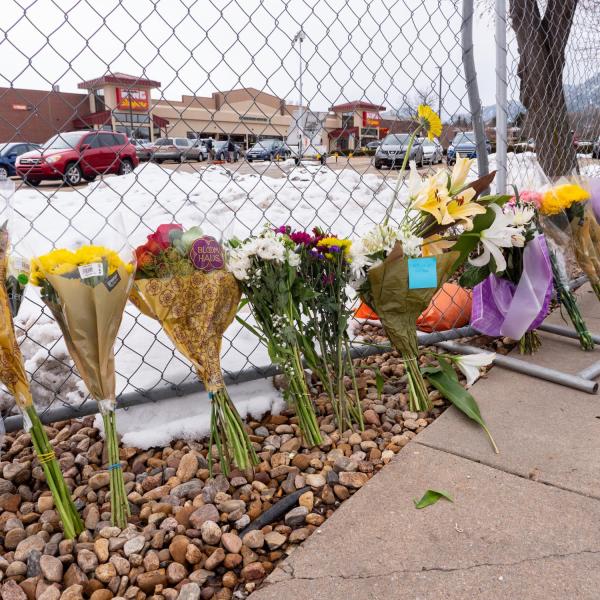 Flowers line a fence surrounding the parking lot where 10 adults, including a police officer, were shot by a lone gunman at the King Soopers at 3600 Table Mesa Dr. (Photo by Glenn Asakawa/University of Colorado)