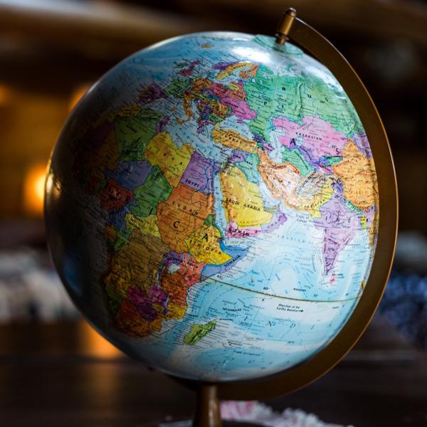 A globe on a wooden desk (Kyle Glenn/Unsplash)