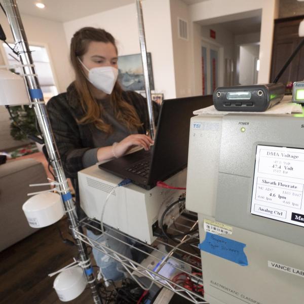 Woman works at large piece of scientific equipment