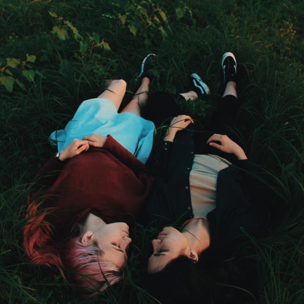 Two people lying in grass together