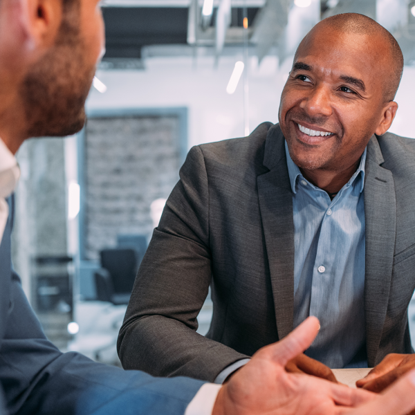 Two professionals in suits talking to one another