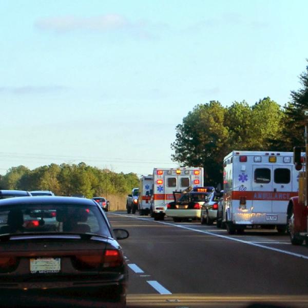 Cars drive past emergency vehicles pulled over in right lane