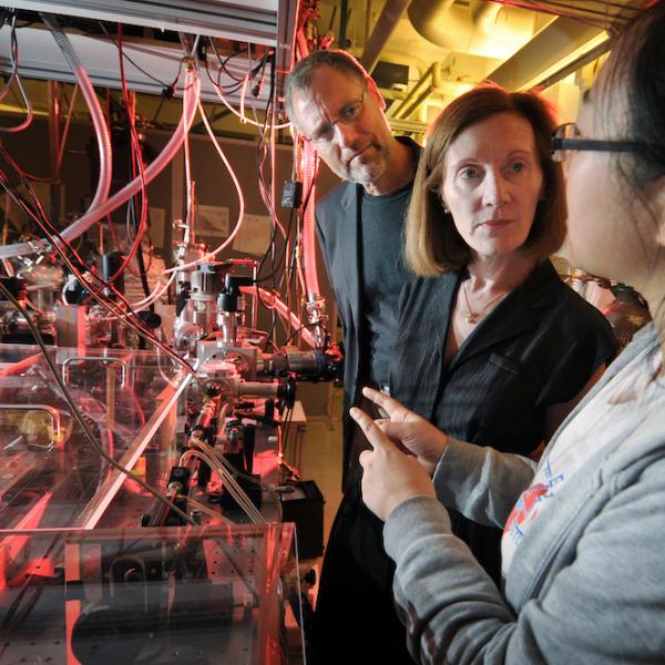 Henry Kapteyn and Margaret Murnane talk to graduate student Qing Li in their lab at JILA