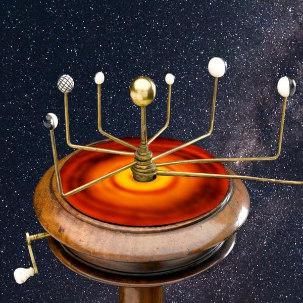 An orrery, a type of device once used to track the movements of the planets, sitting above an infrared image of a hypothetical "protoplanetary" disk that may have divided the solar system early in its history.