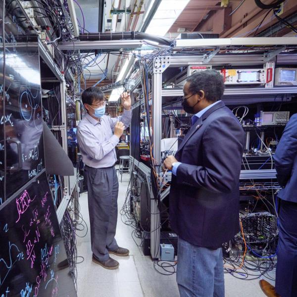 U.S. Rep. Joe Neguse, right, tours the lab of physicist Jun Ye at JILA in December 2021.