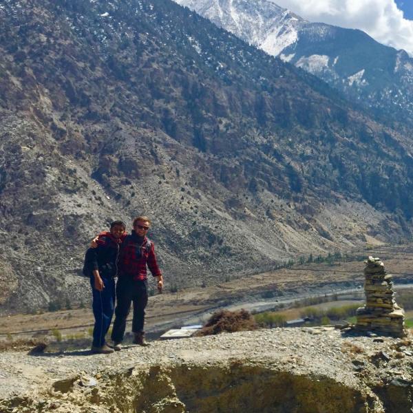 Men standing next to a mountain range.