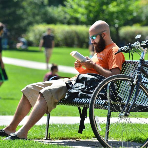 Person reading on a bench on CU Boulder campus.