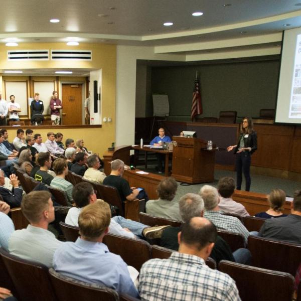 A member pitches to a crowd at a New Venture Challenge event.