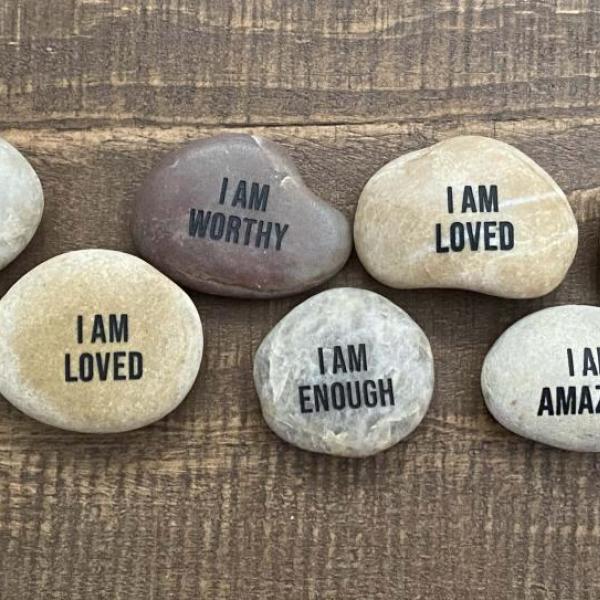 Image of rocks displaying messages of self-affirmation.