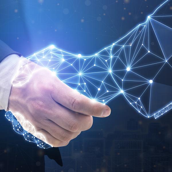 person in business suit shaking hands with an AI arm