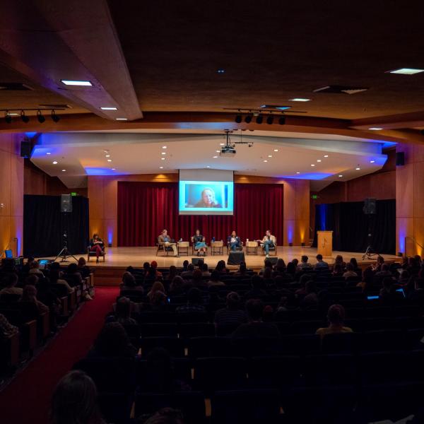 Panelists speak in an auditorium on campus