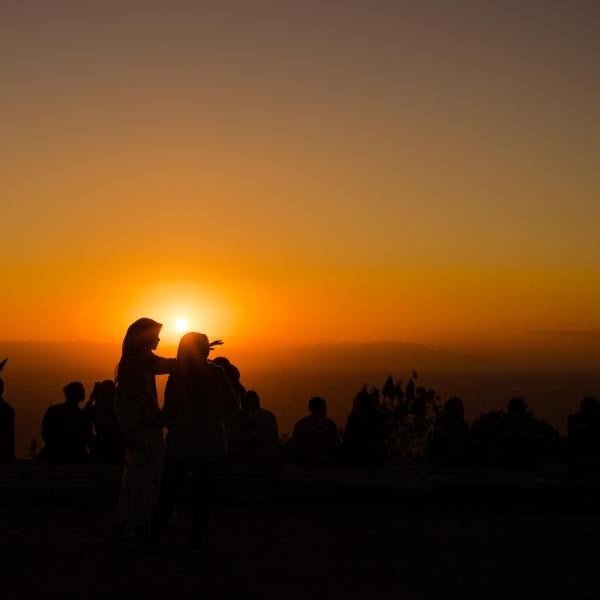 A group of people is seen backlit by a sunset. (Courtesy Pexels/Agung Pandit Wiguna)