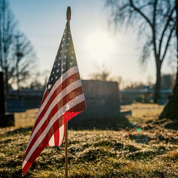 Tiny American flag in ground at cemetery