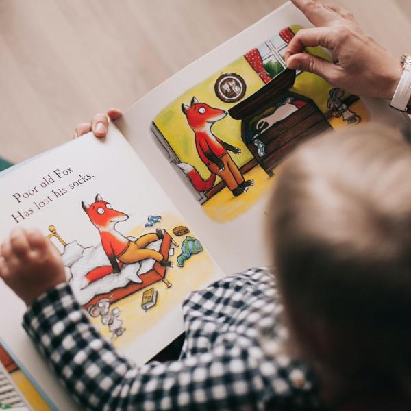 Woman reading a book to a toddler