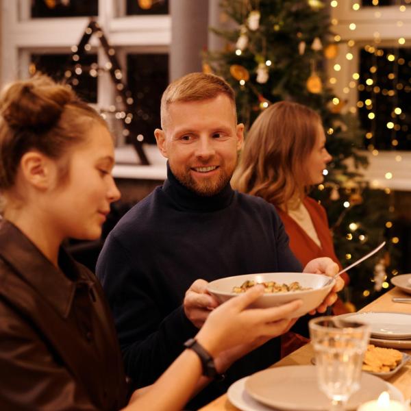 Friends and family gather at a table over the holidays