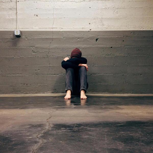A person with head in hands, looking sad