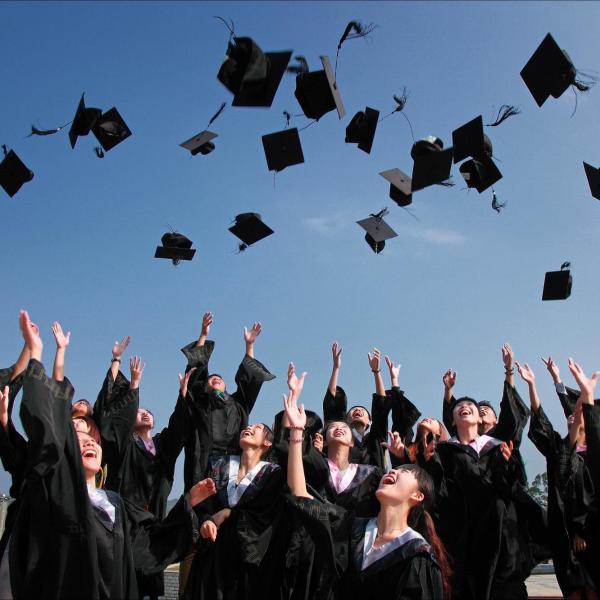 Graduates toss their caps in the air