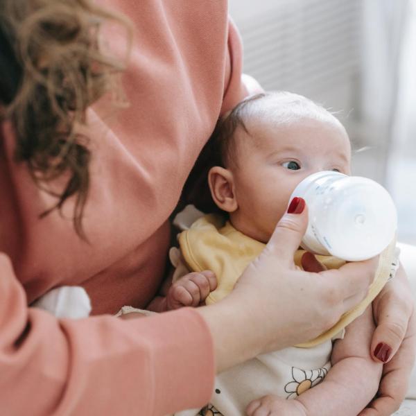 Parent bottle feeds an infant