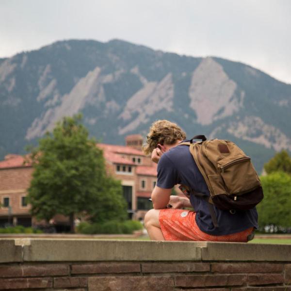 student sitting outside alone on campus