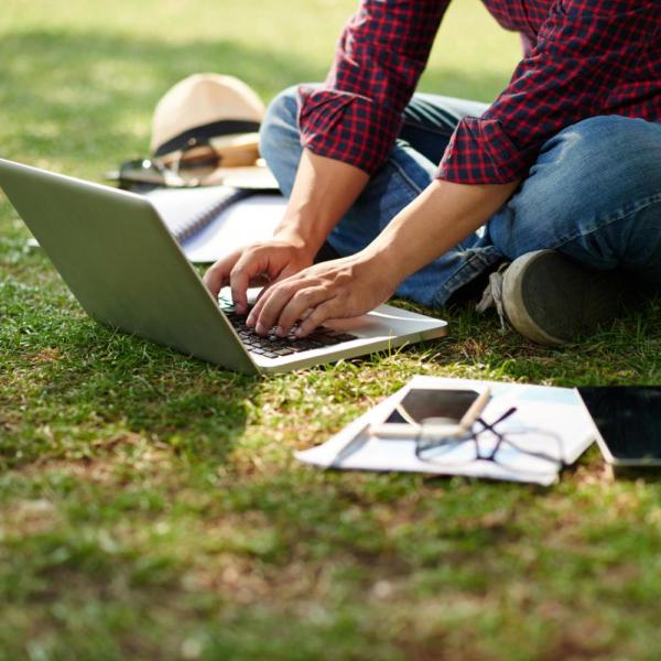 person working outside on laptop