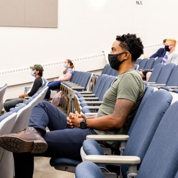 students in a lecture hall, physically distanced and wearing masks
