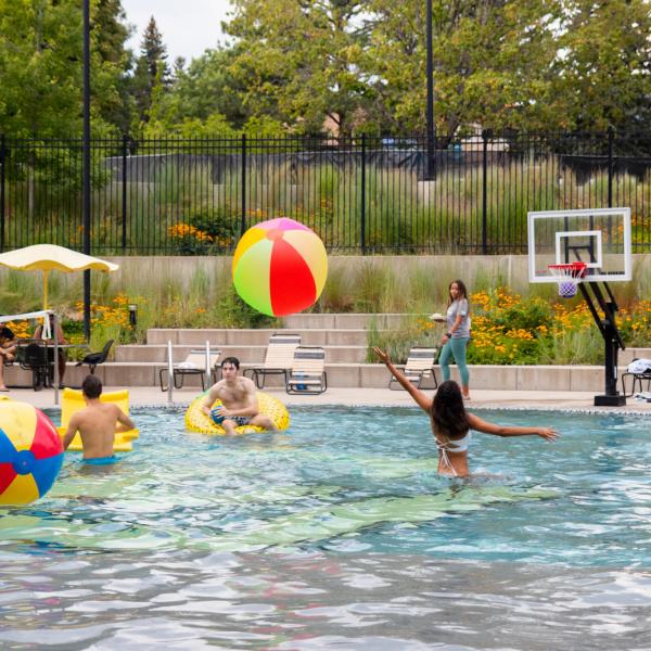 Students swimming in outdoor pool on campus