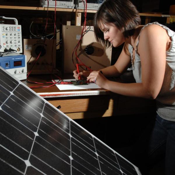Woman writing electronic engineering proposal