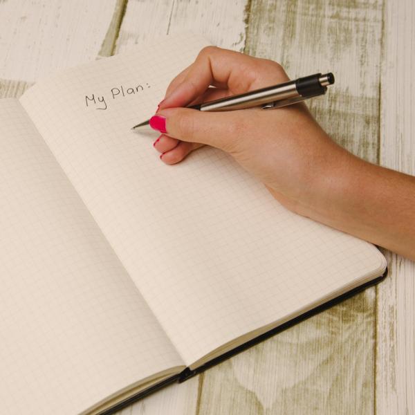 Person writing down plans for New Year's resolutions