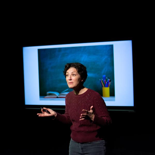 A person speaks on a stage.