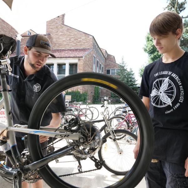 Two students tune up a bike at the UMC Bike Station