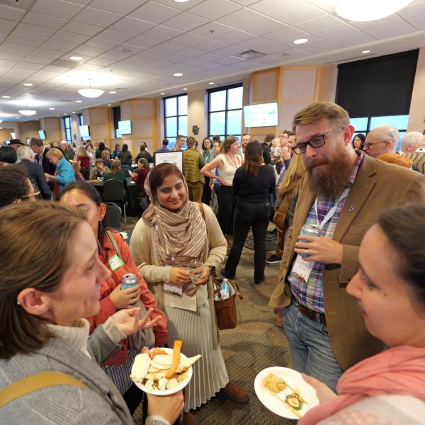 People mingle in a large conference hall.