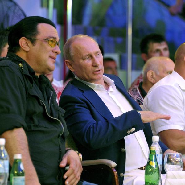 Vladimir Putin sits in a crowd at a sporting event