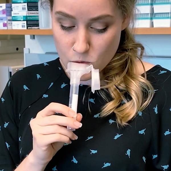A researcher spits in a tube