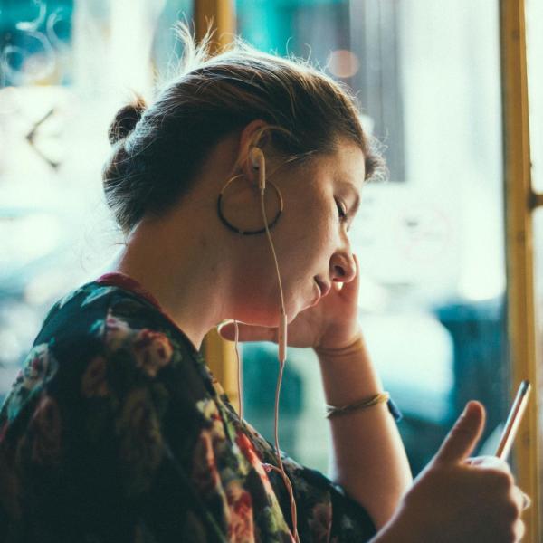 Person with earbuds and iphone