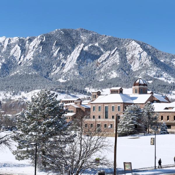 Snowy campus building with Flatirons in the background