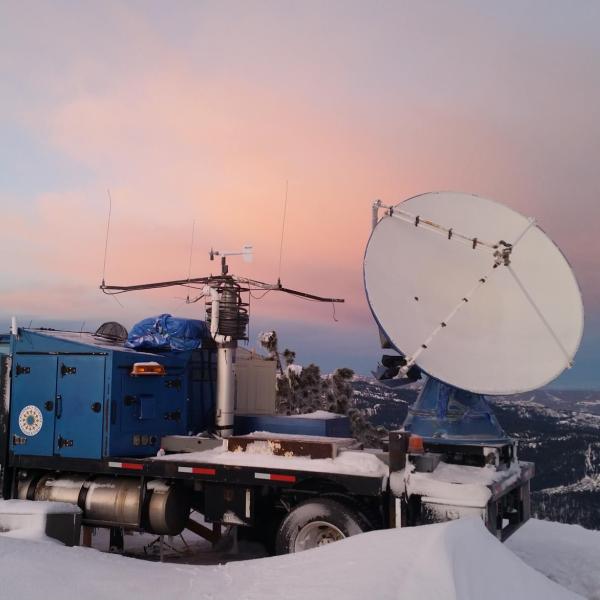 A radar dish mounted on the bed of a truck.