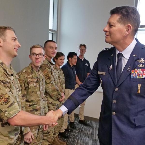 Gen. Thompson shakes hand with an ROTC cadet in fatigues
